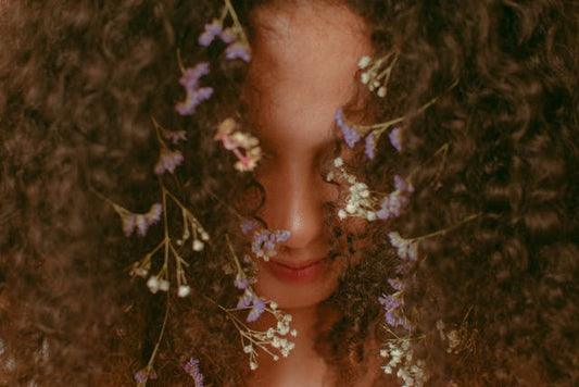 woman with curly hair and flowers in hair